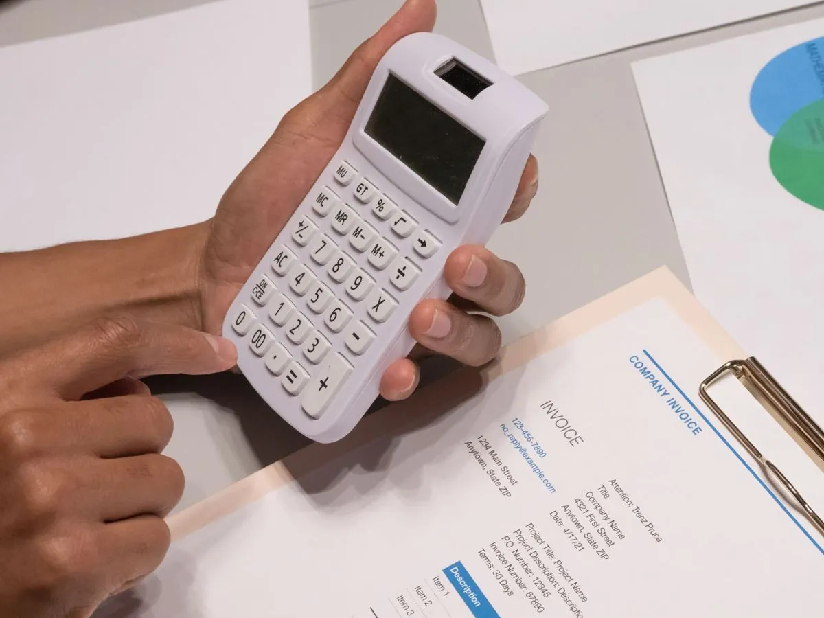 Fatture di carta sparse su una scrivania accanto a una calcolatrice