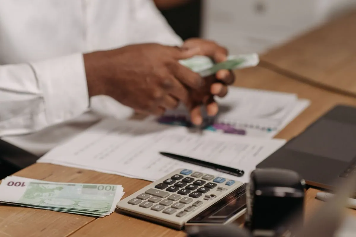 Banconote in euro accanto a una calcolatrice e a dei prospetti stampati