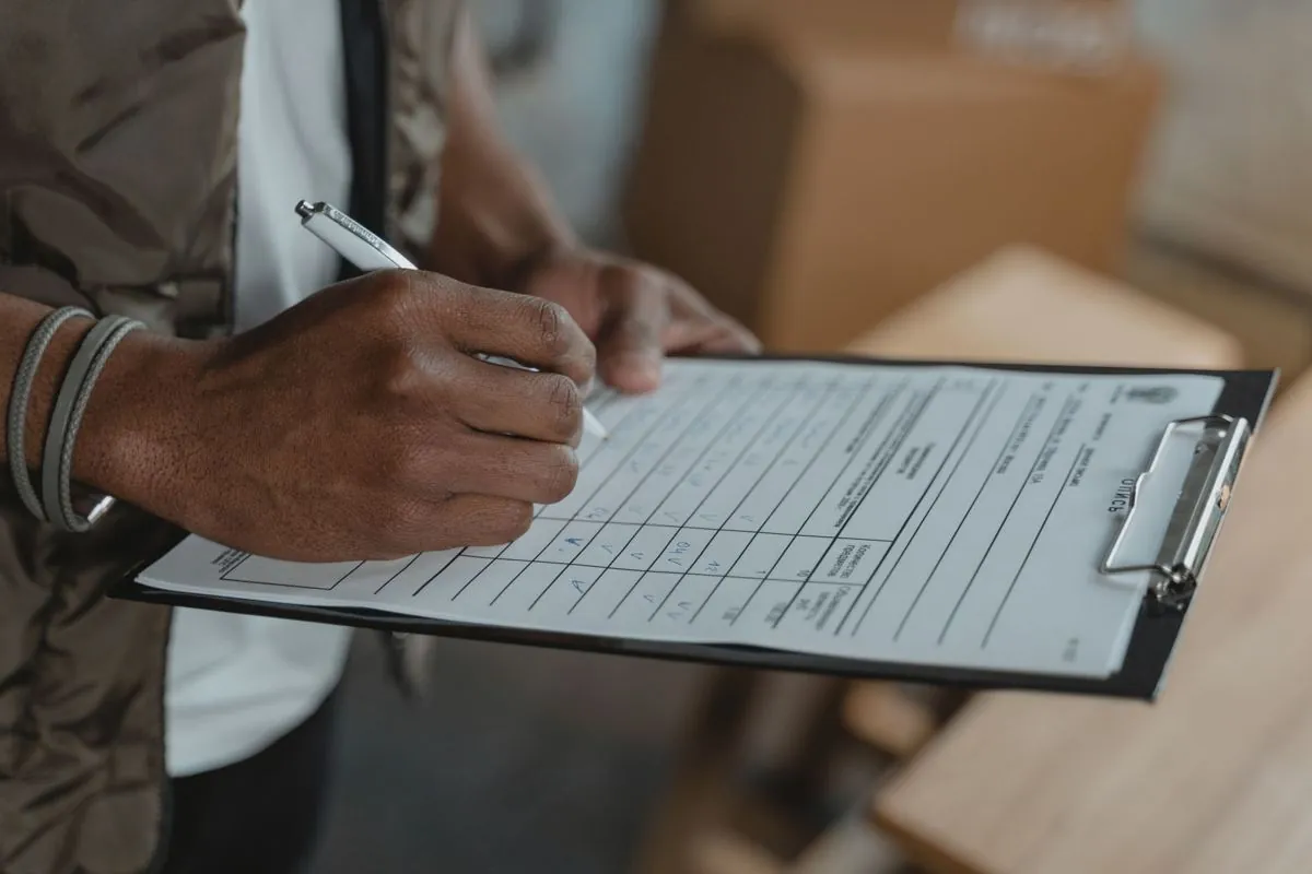 Tecnico che compila un rapportino su appunti accanto agli attrezzi di lavoro