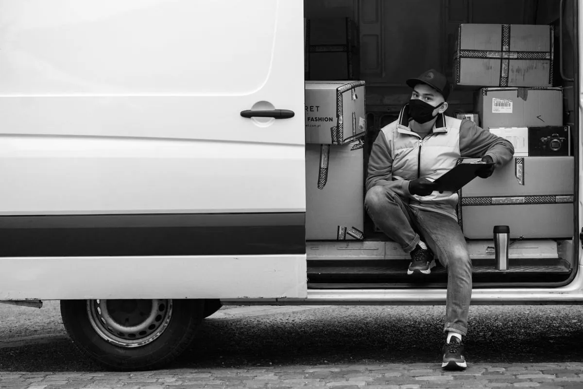 Bolle di consegna appoggiate al volante di un camion mentre l’autista firma