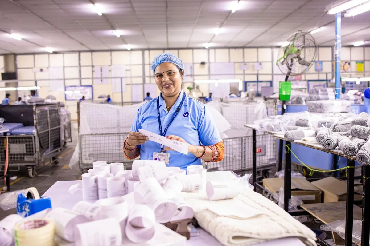 Operaio controlla etichette e lotti su confezioni in un laboratorio alimentare