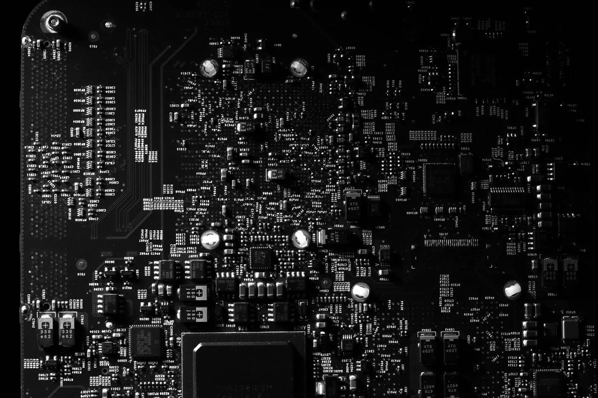 Componenti elettronici divisi in cassettiere accanto a una scheda a circuito