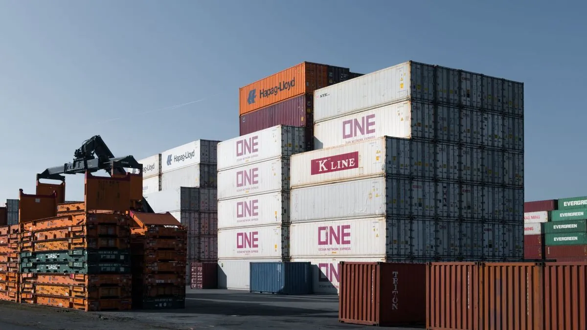 Documenti di spedizione appoggiati su un tavolo con i container sullo sfondo